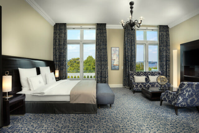 Hotel Atlantic Frontale Ansicht in ein blaues Deluxe Zimmer mit Blick auf die Alster