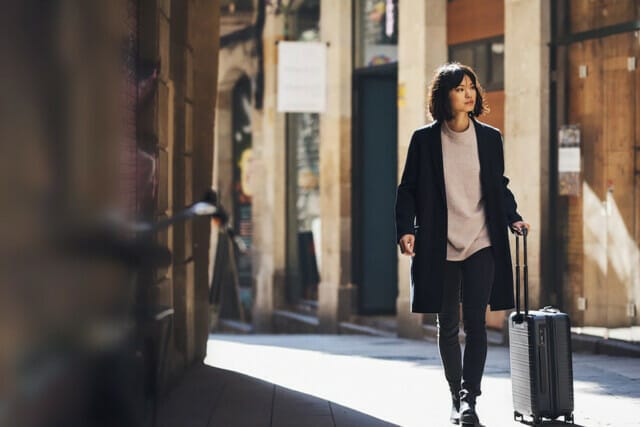 Traveller strolling through the city with her hand luggage.