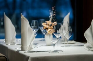 Elegantly laid table with glasses and decorative flower arrangements in the restaurant.
