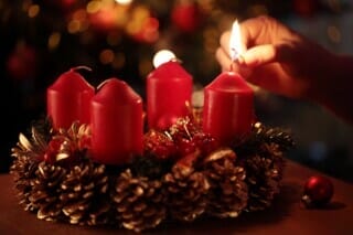 Die erste Kerze des Adventskranzes wird angezündet.