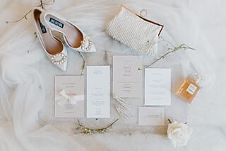 Hochzeitsvorbereitungen, bei denen elegant gestaltete Einladungskarten sorgfältig auf einem Tisch ausgebreitet liegen. Die Einladungskarten zeugen von der Liebe zum Detail, die in die Planung der Hochzeit eingeflossen ist. Die Vorbereitungen werden vom professionellen Team des Hotel Atlantic begleitet, das sich um jedes Detail kümmert, um sicherzustellen, dass der große Tag perfekt wird. Diese Szene unterstreicht die sorgfältige Organisation und die Unterstützung durch das erfahrene Team des Hotel Atlantic.