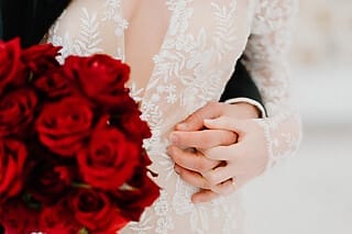 Eine Nahaufnahme zweier Hände, die sich liebevoll halten, aufgenommen bei einer Hochzeit im eleganten Hotel Atlantic in Hamburg. Ein Ehering ist deutlich zu erkennen. Die feine Detailaufnahme betont die Romantik und die emotionalen Momente, die das luxuriöse Ambiente des Hotel Atlantic für eine Hochzeitsfeier bietet.